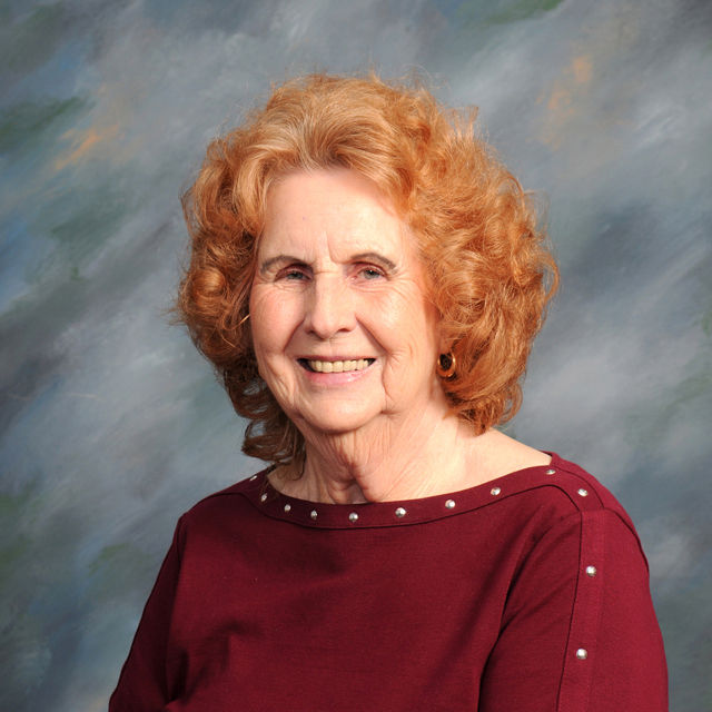 Smiling woman with red hair for Meet Our Team page