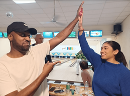 Boulder Bowl, Bowling Alley in Boulder City, Nevada, USA - PHOTO OF TWO BOWLERS HIGH-FIVING WITH BOULDER BOWL SIGN IN THE BACKGROUND. THESE GUESTS CELEBRATED A HOLIDAY PARTY AT BOULDER BOWL.
