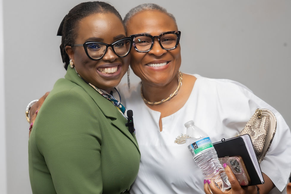 Two smiling individuals embracing, showcasing camaraderie and warmth. One is dressed in a green blazer, and the other in a white outfit, holding a water bottle and a notebook. Clips from September 2025 conference