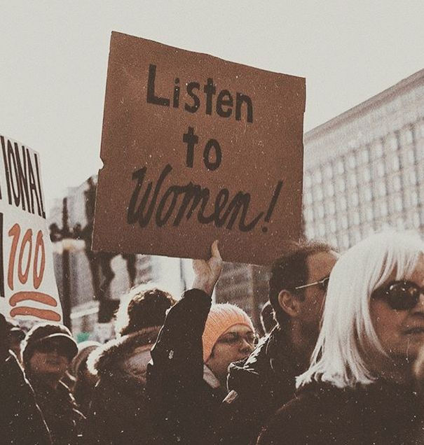 Community uniting in a powerful protest, emphasizing solidarity and the importance of listening to and supporting women.