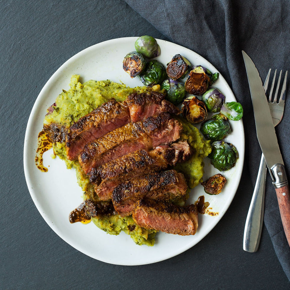 Turmeric rubbed steak on top of kale mashed potatoes and brussels sprouts.