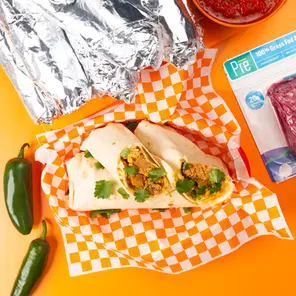 An overhead shot of pile of burritos and Pre ground beef 
