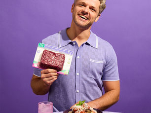 A man holding a package of Pre® Ground Beef