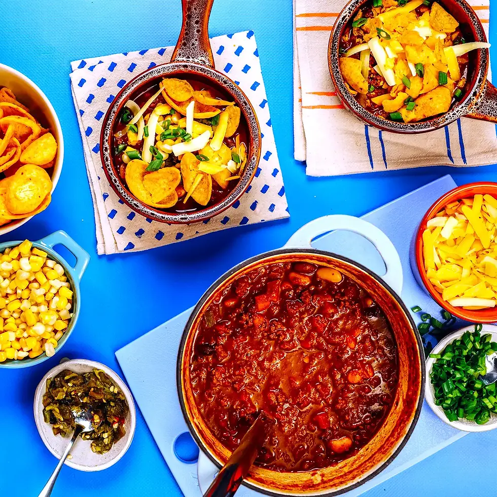 Overhead shot of a big bowl of chili and sides around it