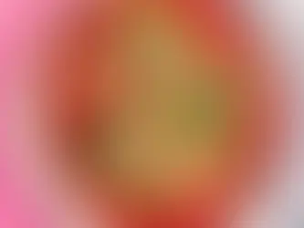 Overhead view of homemade grass-fed, pasture-raised beef meatballs in rich tomato sugo sauce, topped with grated Parmesan cheese and fresh basil on a white ceramic plate against a pink background.