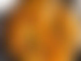 A skillet full of curry with a spoonful being taken out.