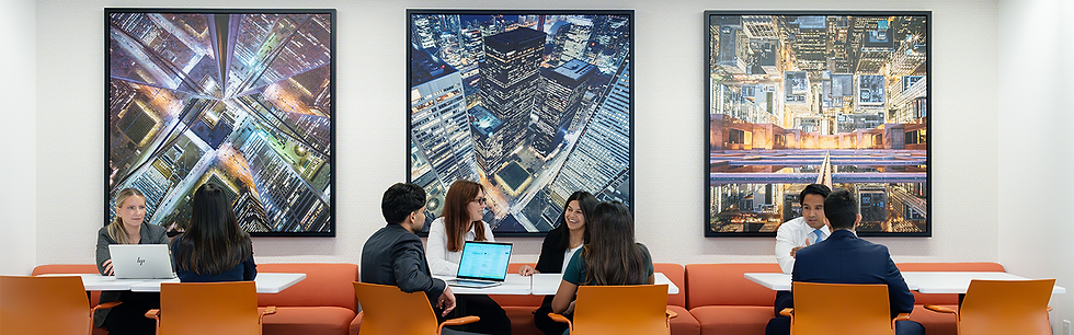 Assis sur des chaises orange, un groupe de personnes est en pleine discussion autour de plusieurs tables.