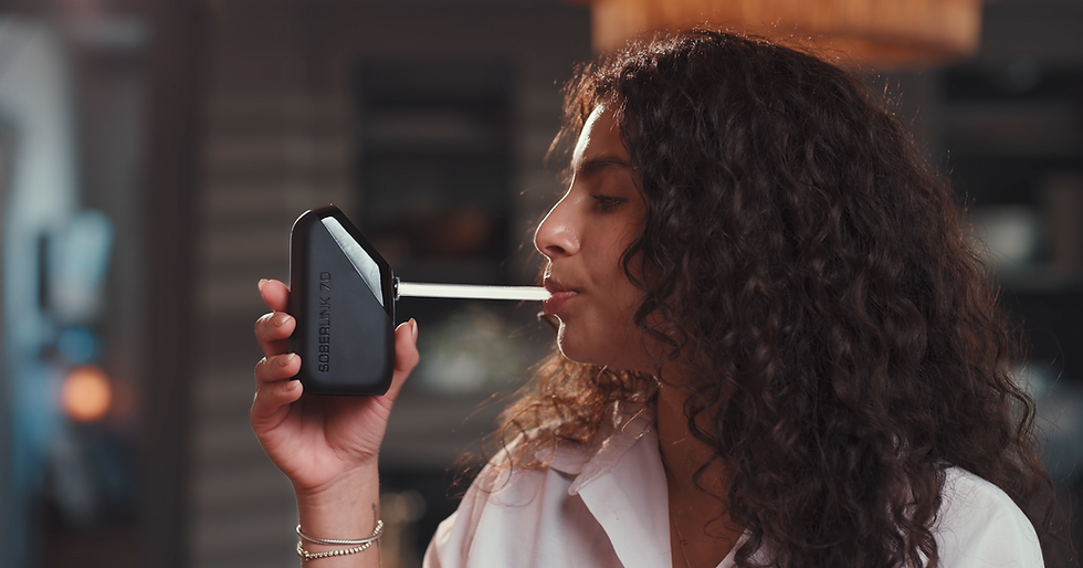 A woman blows into a Soberlink Alcohol Monitoring Device for a product video by Lure Digital.