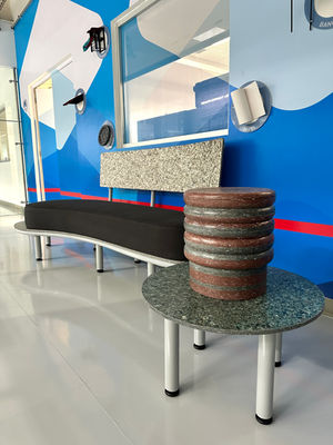 Nombre de la pieza : Sillón y mesa
Cliente : Tetra Pak.
Material :  Polialuminio (envases post consumo reciclados de Tetra Pak) y estructura de metal con pintura electrostática en color gris. 
Impacto : Mostrar a sus clientes la capacidad que tienen sus envases post consumo para lograr muebles con diseño, con flaked, rompemos paradigmas de lo que está establecido.
Usos : Espacio cómodo de cambio de calzado para entrar a ver la maquinaria de envasado y exhibición para venta. 
