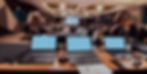 AV control table with laptops and audio equipment managing conference audio recording and live event production