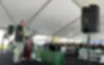 Outdoor PA system rental near Nashville with speakers, microphones and presentation audio setup under a large event tent.