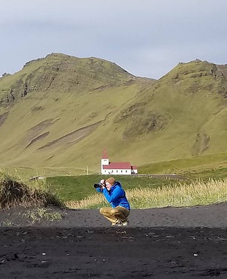 Jonathan Klein taking photos in Iceland on a black sand beach