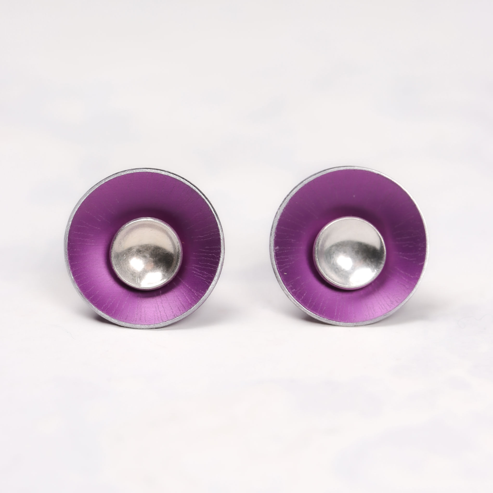 Pink aluminium and silver stud earrings on a white background