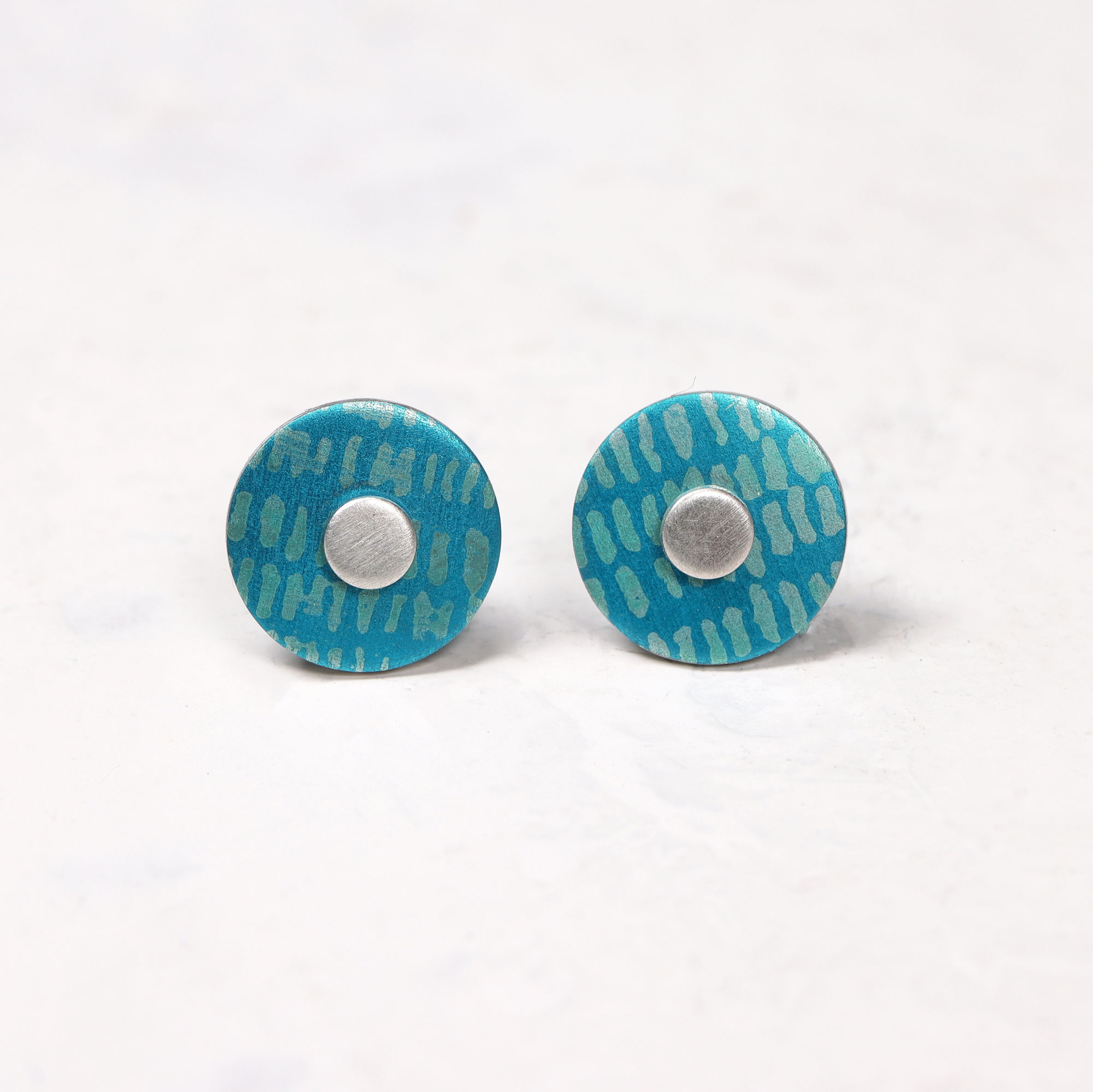 Turquoise and teal blue round small silver stud earrings on white background