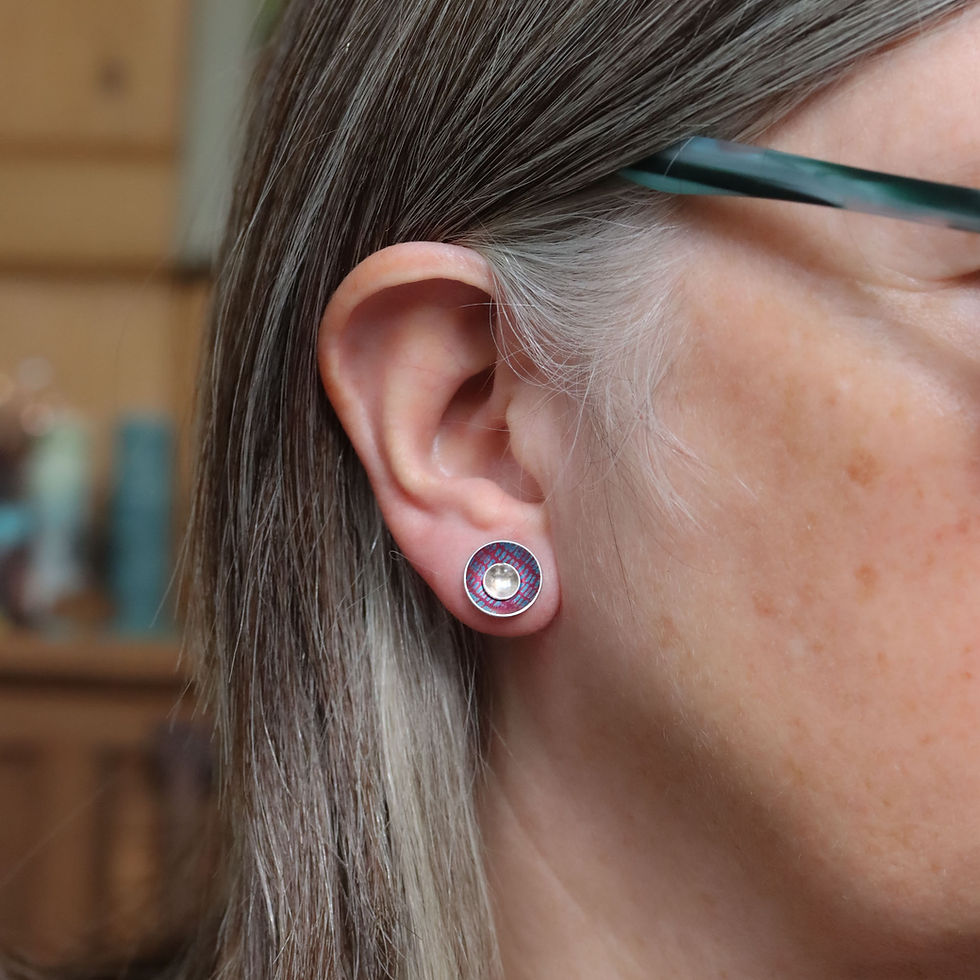 Dark pink and turquoise blue interchangeable silver stud earrings on a white woman