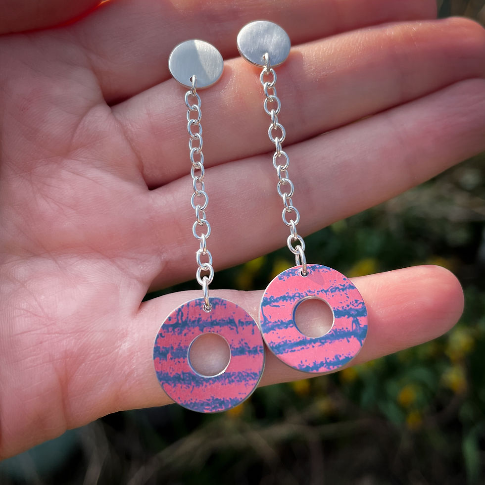 Thumbnail: Pink and blue aluminium washer long drop dangly silver earrings on a white woman's hand outside