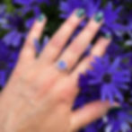 Magenta pink and turquoise aluminium small silver rivet ring on white woman with purple flowers