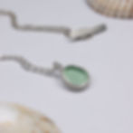 Thumbnail: Seafoam blue sea glass and silver minimalist pendant necklace with sea shells on a white background