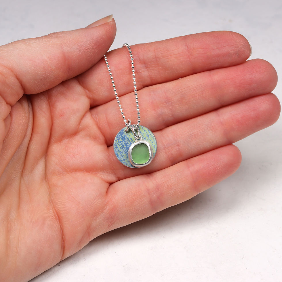 Thumbnail: Green and blue sea glass and aluminium silver cluster necklace in a white woman's hand