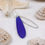 Thumbnail: Royal blue sea glass teardrop and silver duo necklace on a white background surrounded by shells and draped over a star fish
