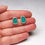 Thumbnail: Teal green sea glass and silver stud earrings on a white background in white woman's hand