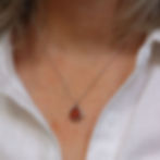 Thumbnail: Dark orange sea glass and silver pendant necklace on a white woman wearing a cream linen shirt