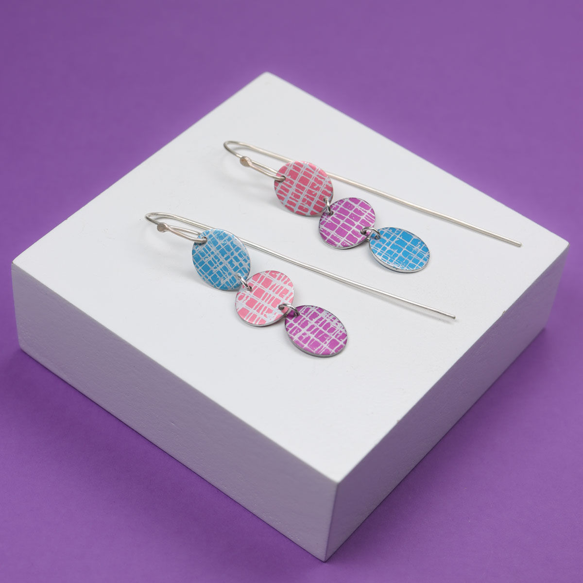 Hydrangea print triple silver earrings on a purple background