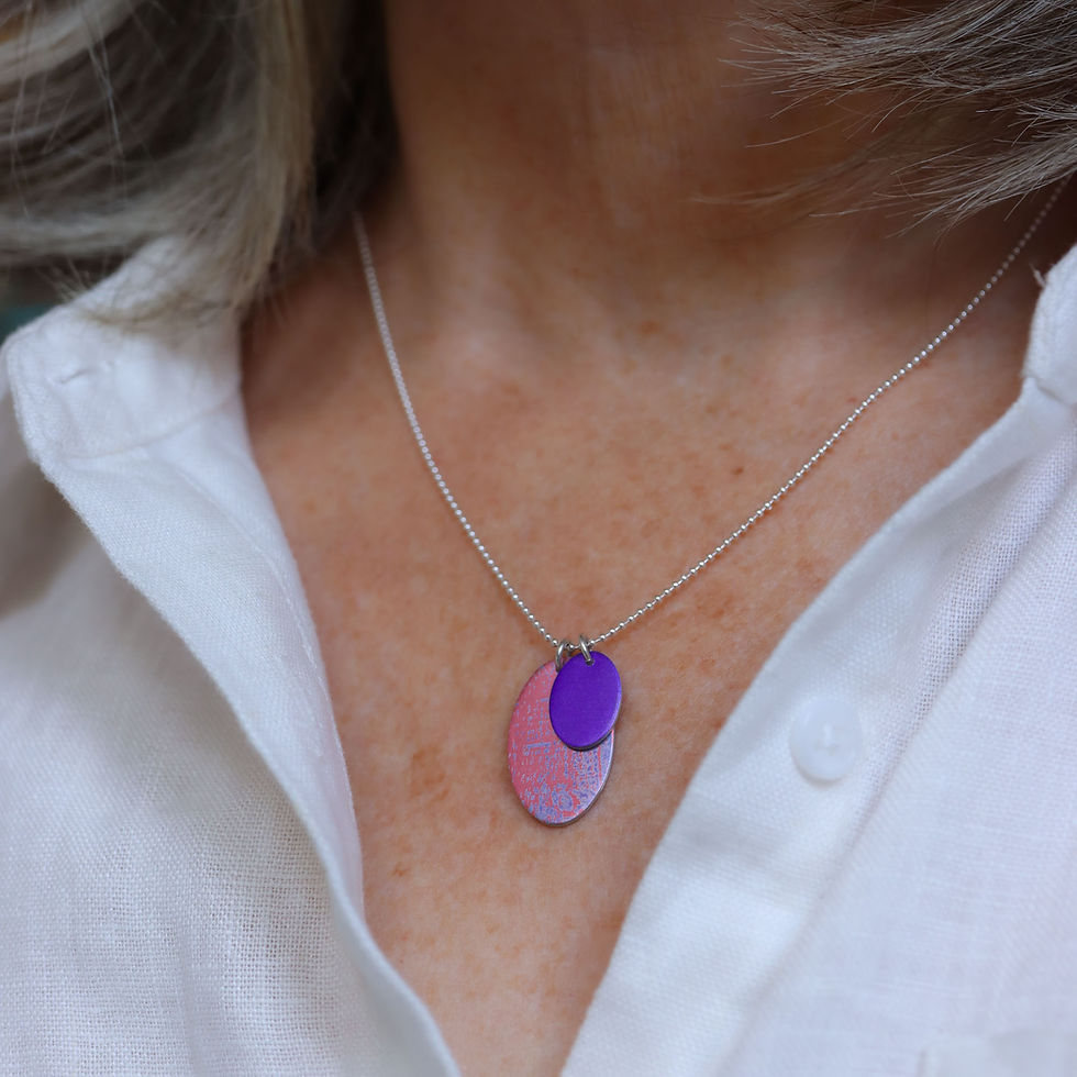 Bubblegum pink and purple oval silver duo cluster necklace on a white woman wearing a cream linen shirt