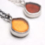 Thumbnail: Two orange sea glass and silver pendant necklaces side by side, one golden honeycomb one dark treacle colour