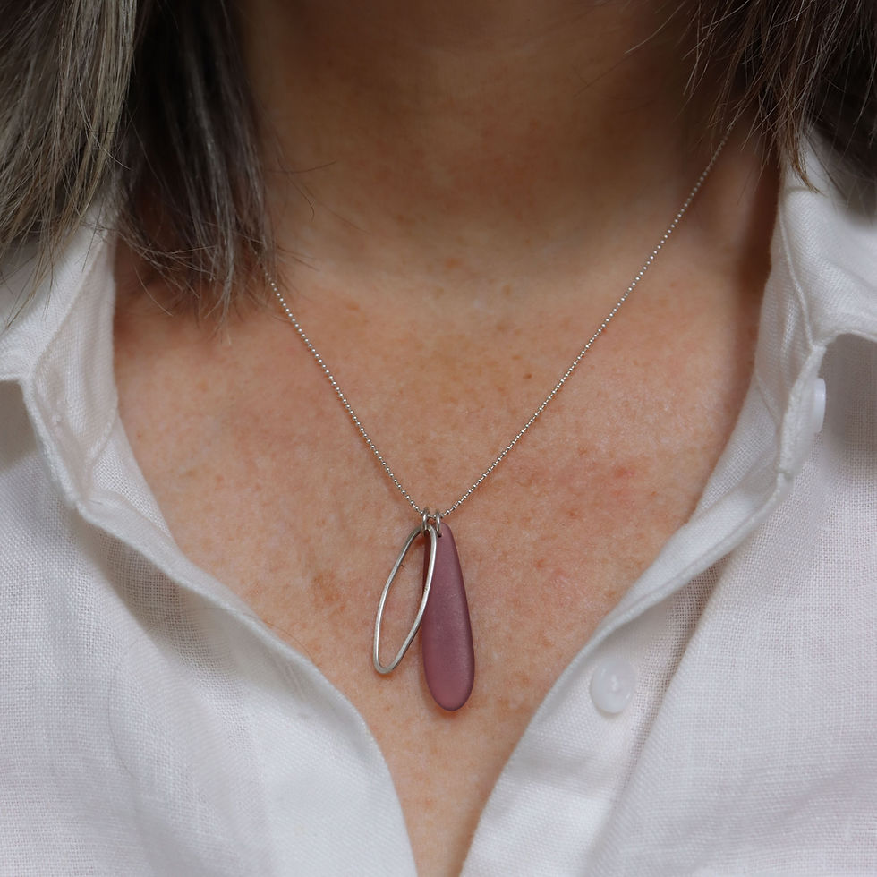 Plum purple teardrop cultured sea glass and silver duo cluster necklace on a white woman wearing a cream linen shirt
