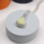 Thumbnail: Pastel lemon yellow milk sea glass silver pendant necklace on grey plinth a white background