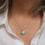 Thumbnail: Green and blue sea glass and aluminium silver cluster necklace with a white woman wearing a cream linen shirt