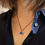 Thumbnail: Royal blue sea glass and oxidised silver pendant on a white woman wearing a dark blue shirt