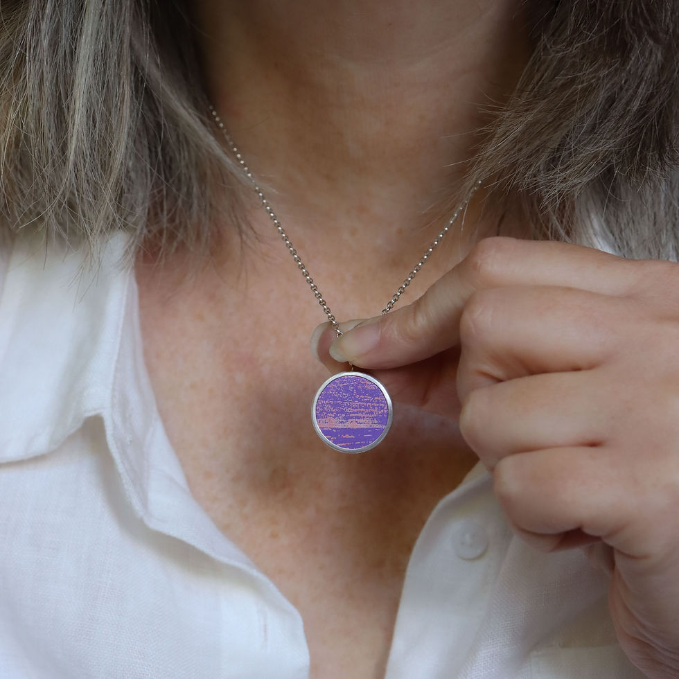 Thumbnail: Purple and pink aluminium and silver pendant necklace on a white woman in a cream linen shirt