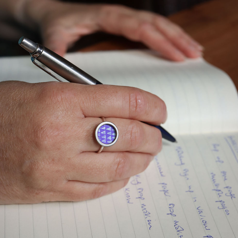 Purple aztec aluminium silver rivet ring on a white woman with pen and notebook
