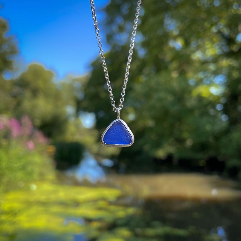 Thumbnail: Royal blue sea glass and silver pendant by a river