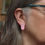 Thumbnail: Pink and blue nature inspired oval aluminium and silver stud earrings on a white woman