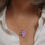 Thumbnail: Pink and lilac purple sea glass, aluminium and silver cluster necklace on a white woman wearing a cream linen shirt