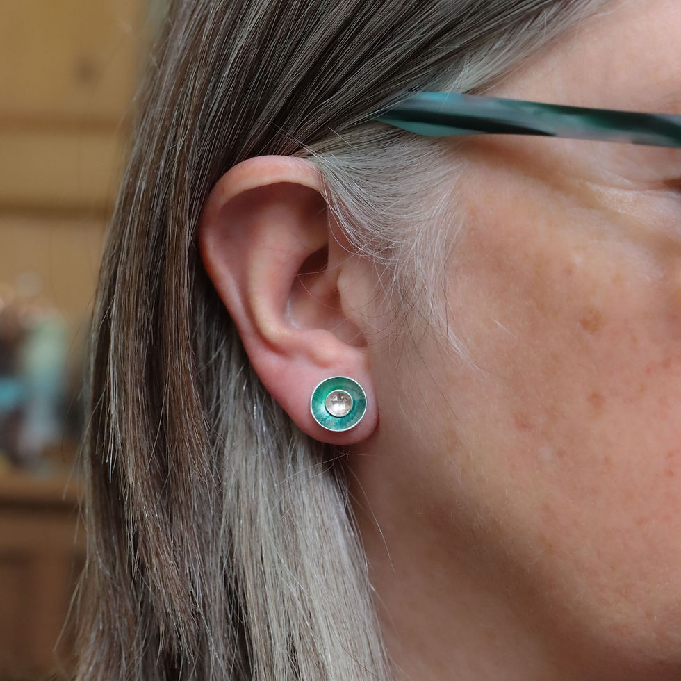 Green aluminium and silver interchangeable stud earrings on a white woman