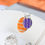 Thumbnail: Necklace with orange and purple ovals on silver chain in white trinket dish with orange ribbon behind