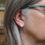 Thumbnail: Dark midnight blue anodised aluminium silver stud earrings on a white woman