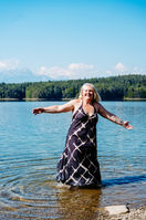 Frau bei einer Portraitsession am Forstsee in Kärnten, umgeben von Wald und Wasser, genießt einen ruhigen Moment in der Natur voller Leichtigkeit, Ausgeglichenheit und Selbstwahrnehmung.