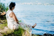 Natürliche Frauenportraitfotografie am Bleistätter Moor in Kärnten. Eine Frau genießt die Ruhe der Natur, das Wasser und einen besonderen Moment für sich.