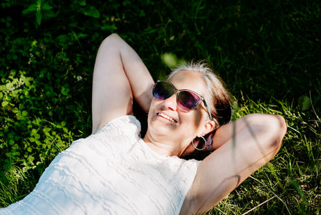 Natürliche Frauenportraitfotografie am Bleistätter Moor in Kärnten. Eine Frau genießt die Ruhe der Natur, das Wasser und einen besonderen Moment für sich.