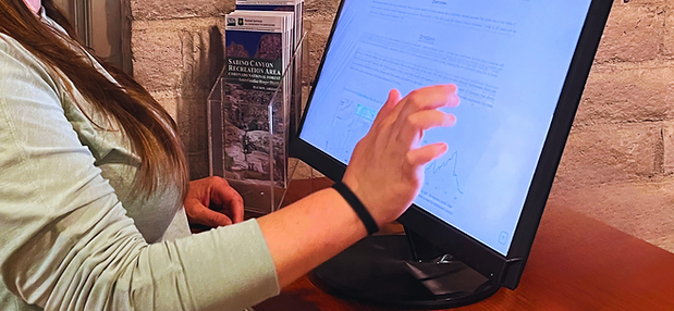 Visitor touching kiosk screen