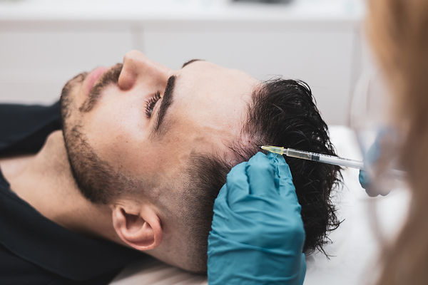 Detail of a young man receiving hair treatment in a beauty salon. Man having mesotherapy s