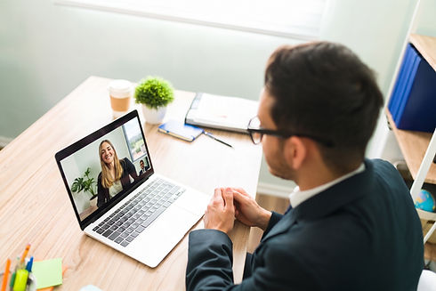 Man video calling woman on laptop at desk
