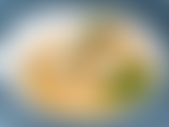 Grilled fish with sprigs of thyme on creamy sauce, set on cooked greens. Served on a blue-rimmed plate, evoking a gourmet presentation.