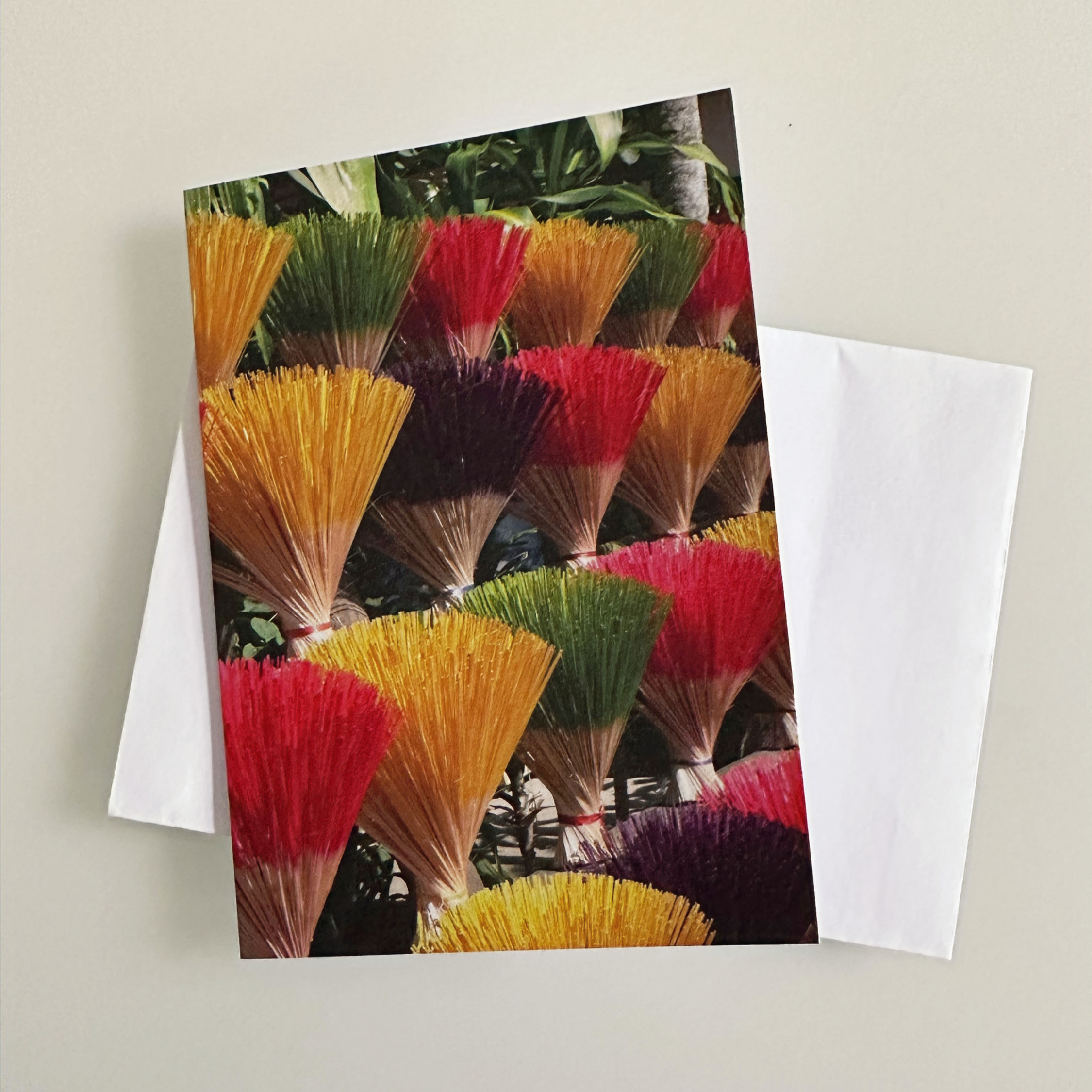 A row of colourful joss sticks on a greeting card and white envelope