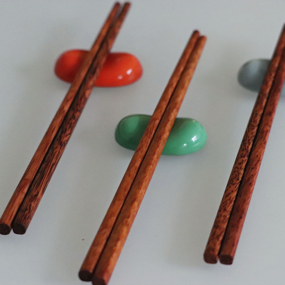 Thumbnail: Three pairs of wooden chopsticks resting on colorful ceramic holders.